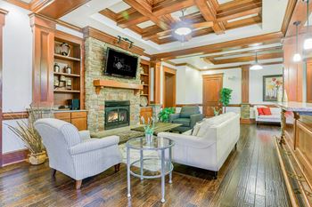 A living room with a fireplace and a flat screen TV at The Lofts at Reynolds Village Apartments, North Carolina